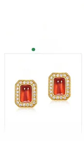 Close-up of vintage gold earrings with rectangular red garnet and halo of zircons