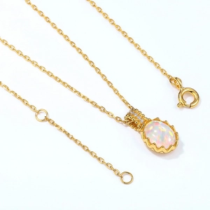 Macro detail of oval opal pendant on gold S925 silver chain with zircon accents