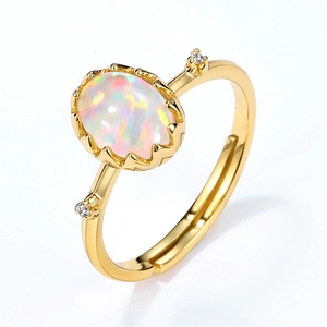 Détail d'une bague opale vintage avec monture couronne dorée et petits cristaux