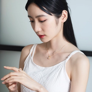 Detail of elegant gold-plated 925 silver necklace and ring set with oval opal stones