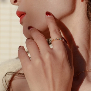 Gros plan d'une boucle d'oreille dorée avec quartz rose sur mannequin en lumière chaude