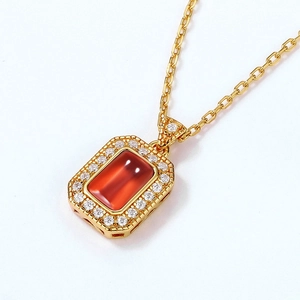 Makroaufnahme der goldenen Kette mit rechteckigem Granatanhänger und Kristallen