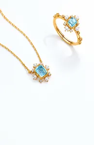 Dettaglio del set di gioielli a fiocco di neve con topazio blu e perle in argento dorato