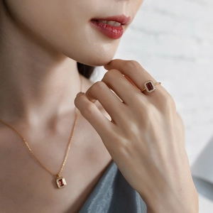 Detail of red garnet necklace and ring set in gold plated 925 silver on model