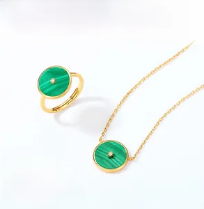 Gros plan d'un ensemble bague et collier en or avec malachite verte et zircons brillants