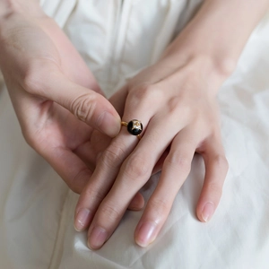 Vintage 925 silver gold ring with black agate clover and star motif on white fabric
