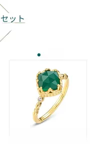 Detailed macro of vintage adjustable gold ring featuring a square green gemstone