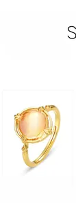 Detailed macro view of an adjustable gold-plated ring featuring a pink multifaceted stone
