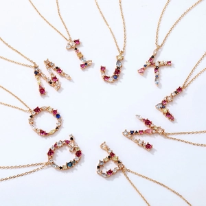 Display radiale di collane con lettere in argento S925 dorato e zirconi colorati