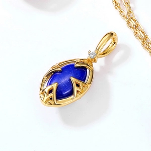 Détail macro du pendentif en argent doré avec lapis-lazuli et motif géométrique évidé