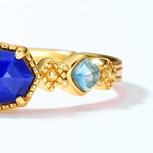 Macro detail of vintage gold ring with blue lapis hexagon stone and beaded engraving