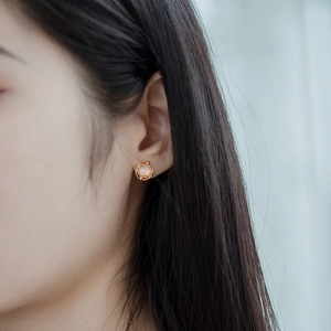 Minimalist 925 silver gold-plated pink crystal bird stud earring on a female model's ear