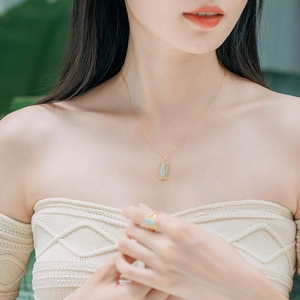 Détail du pendentif et de la bague en amazonite avec placage en argent 925 doré sur modèle