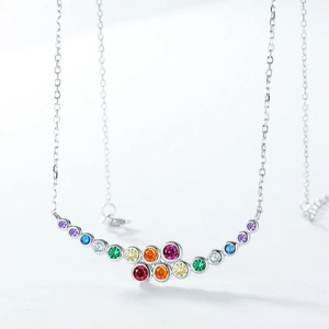 Macro detail of rainbow zircon pendant necklace featuring colorful stones on silver chain