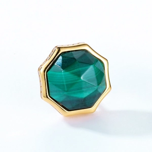Macro detail of octagonal malachite earring featuring an engraved golden metal base