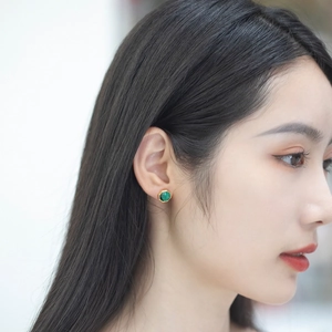 Close-up of a vintage octagonal malachite earring in 925 silver on a woman ear