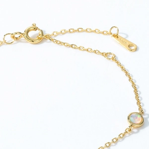 Detail of S925 sterling silver gold bracelet with iridescent opal and lobster clasp