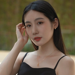 Detail of 925 sterling silver 10K gold conch pendant and earrings set on female model