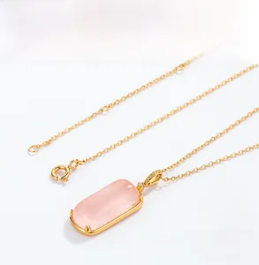Detailed close-up of a pink gemstone pendant on a gold chain with four-prong setting
