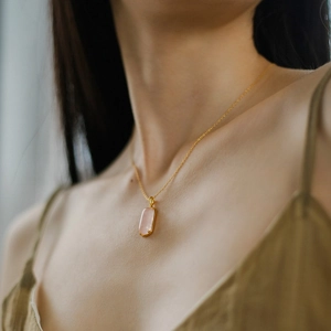 Elegant 925 silver gold chain necklace with a rectangular pink gemstone pendant on a model
