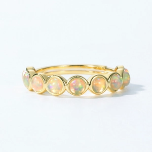 Elegant gold band ring with seven round synthetic opals featuring vibrant fire colors