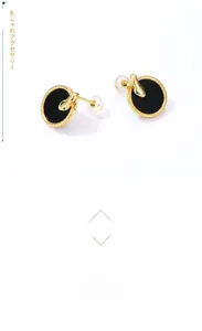 Detailed view of snake-shaped earring in gold with black onyx stone and green crystal eyes