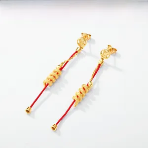 Macro shot of S925 silver snake earrings with red tassels and gold coin design