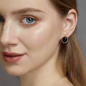 Close-up of vintage gold round earring with black onyx inlay on a female model