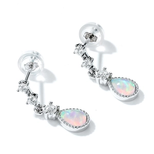 Detailed macro view of silver earrings featuring pear-cut opal stones and white zircons