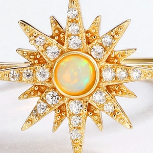 Macro shot of sunburst ring with central opal stone and sparkling zircon accents