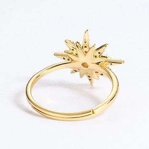 Macro view of gold sunburst ring with starburst pattern and shimmering center stone