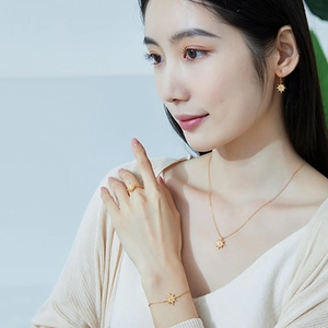 Close-up of a model wearing a gold star-shaped jewelry set with champagne gemstones