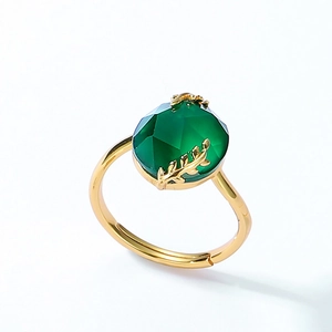 Macro detail of gold-plated leaf band setting with green agate gemstone in natural style