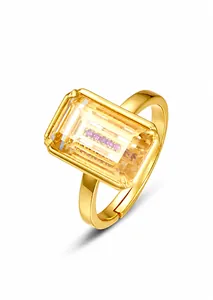 Detail eines vergoldeten verstellbaren Rings mit gelbem Stein und rosa Diamanteinlage