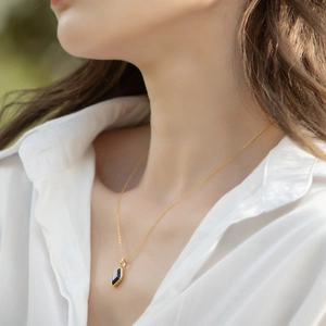 Lapis lazuli geometric pendant in gold finish worn on a delicate gold chain necklace