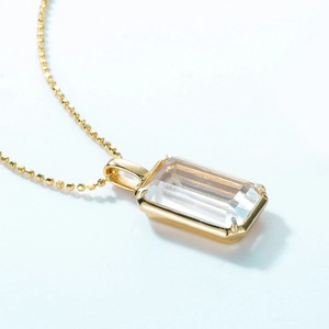 Makroaufnahme von rechteckigem weißem Kristallanhänger an eleganter goldener Kette