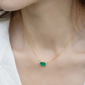 Close-up of cute malachite cat head pendant in 10K gold plated silver on a female neck