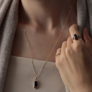 Detail of S925 silver necklace and ring set with black sandstone on a female model