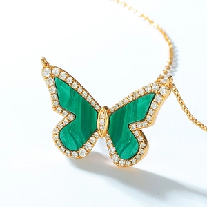 Macro shot of malachite butterfly pendant with gold plating and cubic zirconia inlay