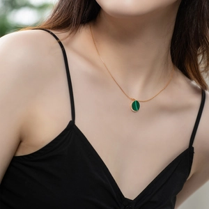 Close-up of model wearing a round malachite pendant necklace with sparkling accents