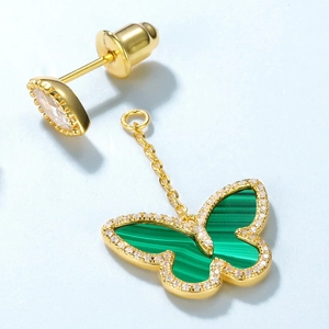 Close-up of gold butterfly earrings with green malachite texture and pavé crystals