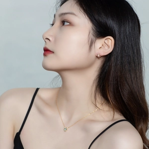 Detail view of model wearing S925 silver necklace and blue topaz starburst earrings