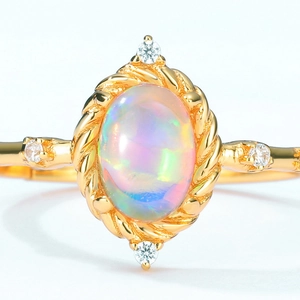 Vintage gold opal ring with oval gemstone and twisted rope border detail