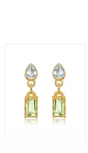Macro detail of retro gold drop earrings with blue pear and green rectangle gemstones