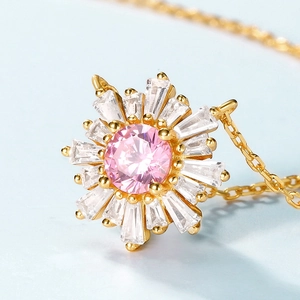 Vue macro du pendentif soleil avec zircon rose central et pierres taille en degrés