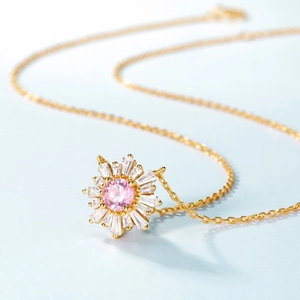 Collier fleur dorée avec pierre rose ronde et cristaux d'oxyde de zirconium micro-sertis