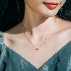 Detailed view of an S925 silver necklace with three elegant pearls on a gold chain