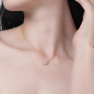 Gros plan du collier tournesol doré avec zircon rose sur le cou du mannequin