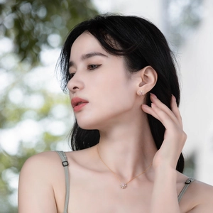 Gros plan d'un ensemble collier et boucles d'oreilles fleuris à pierres roses