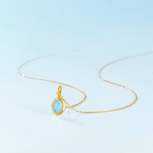 Elegant gold S925 silver necklace featuring an oval synthetic opal pendant with blue fire